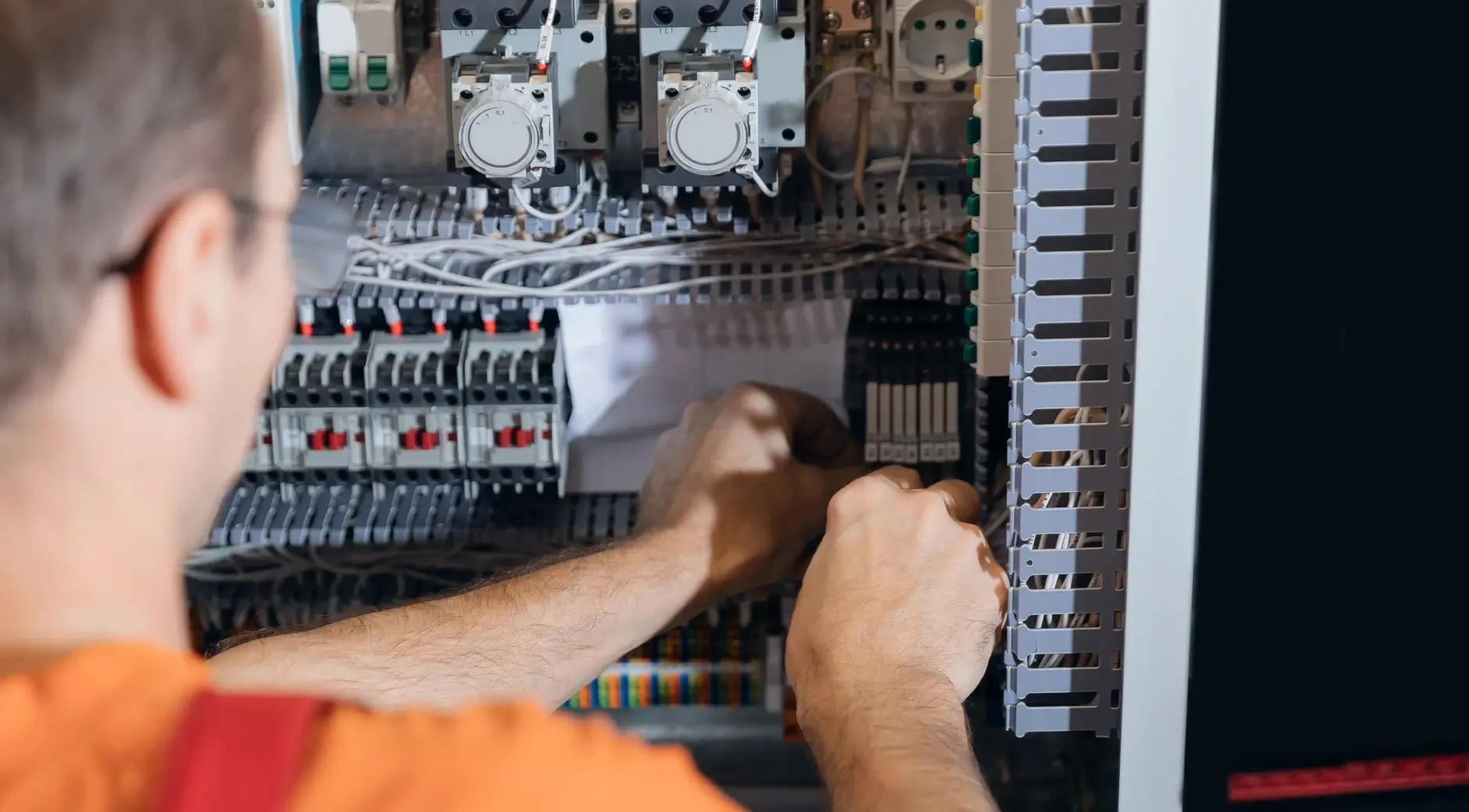 Technician wiring and assembling an industrial control panel