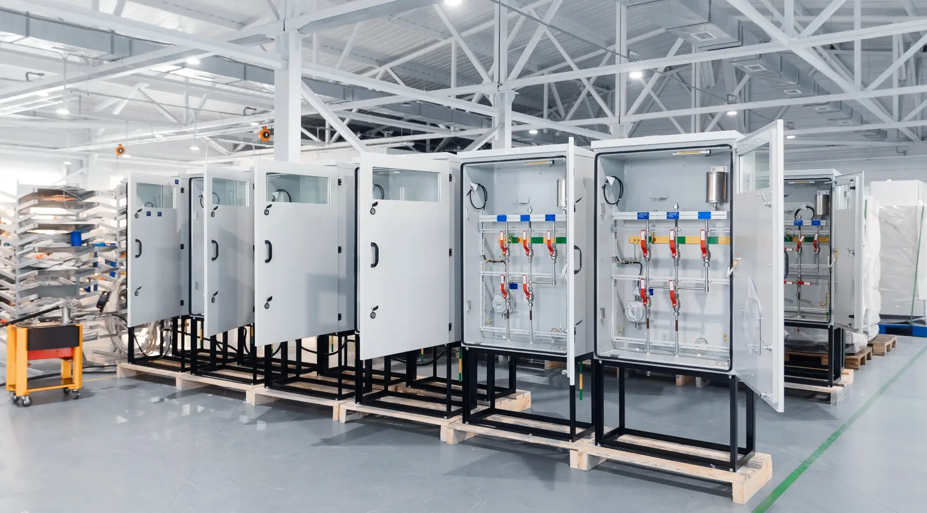 Assembled industrial electrical enclosures staged for shipping in a manufacturing facility