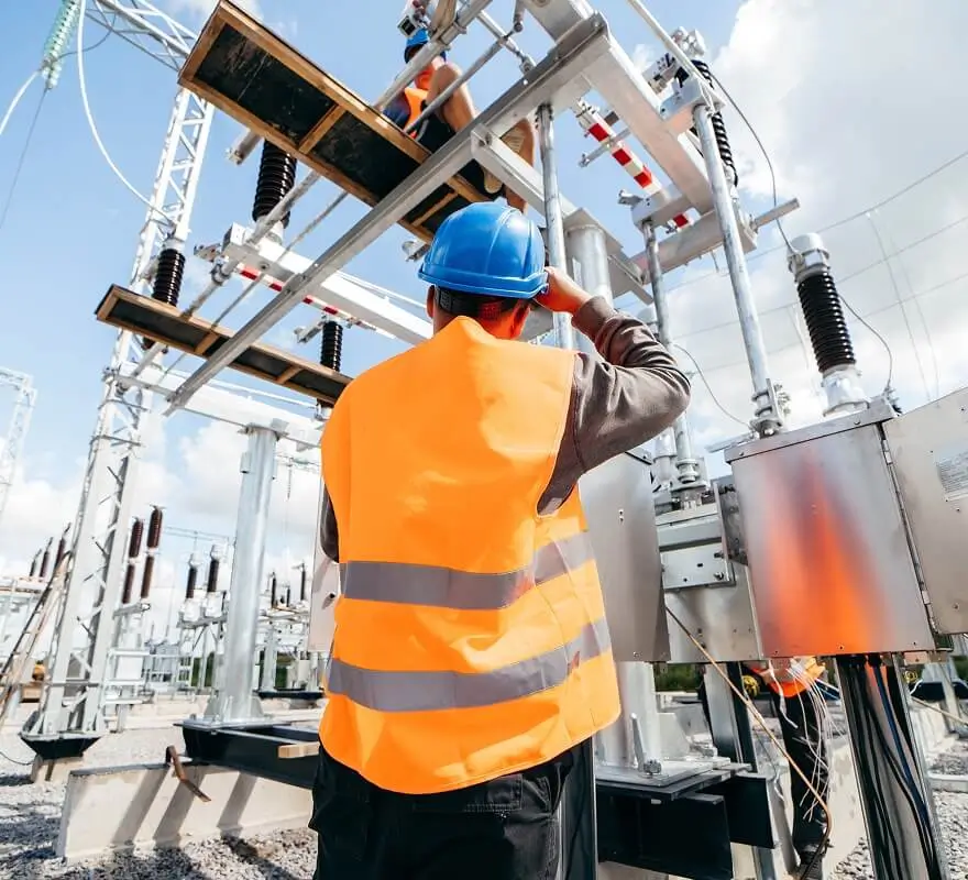 Electrical engineer inspecting industrial power equipment at an outdoor facility